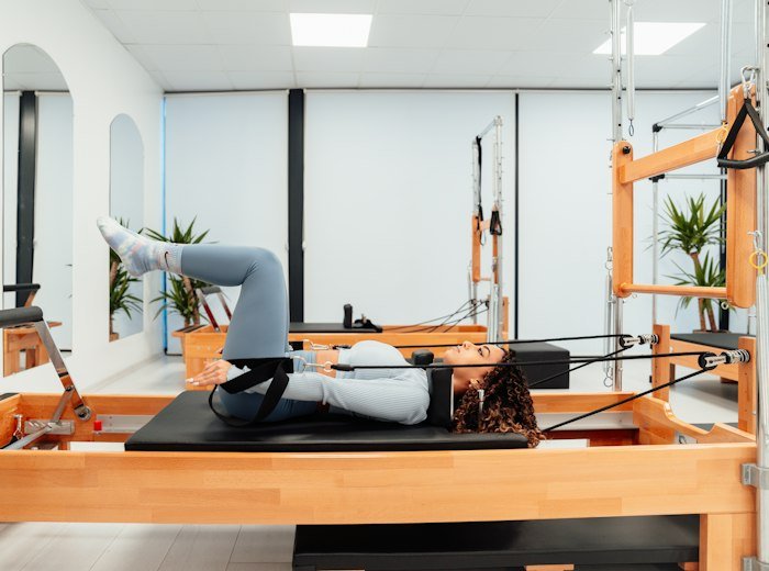 A member lying on a reformer in a gentle stretch